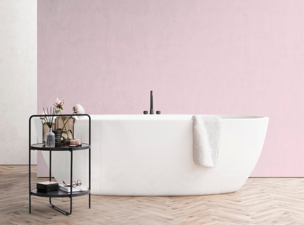 Bathtub with a chair and a white wall berge interiør lite rundt bord sort